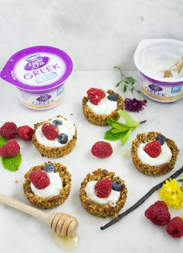 Healthy Breakfast Granola cups filled with yogurt and fresh berries and drizzled with honey