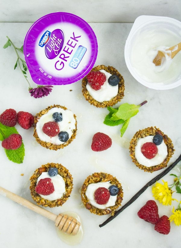 Healthy Breakfast Granola Cups with yogurt and berries with a tub of yogurt on the side