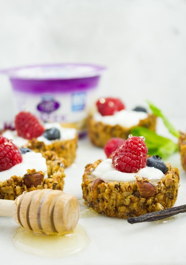 side view of healthy homemade Granola Cups filled with yogurt, berries and honey