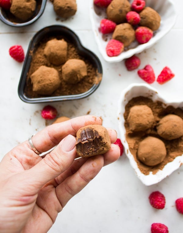 chocolate truffles recipe on heart plates for valentine surrounded by raspberries