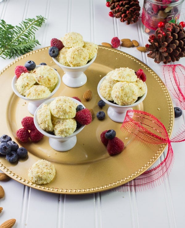 Almond Crunch Greek Yogurt Cheesecake Bites in four white cups on a golden plate