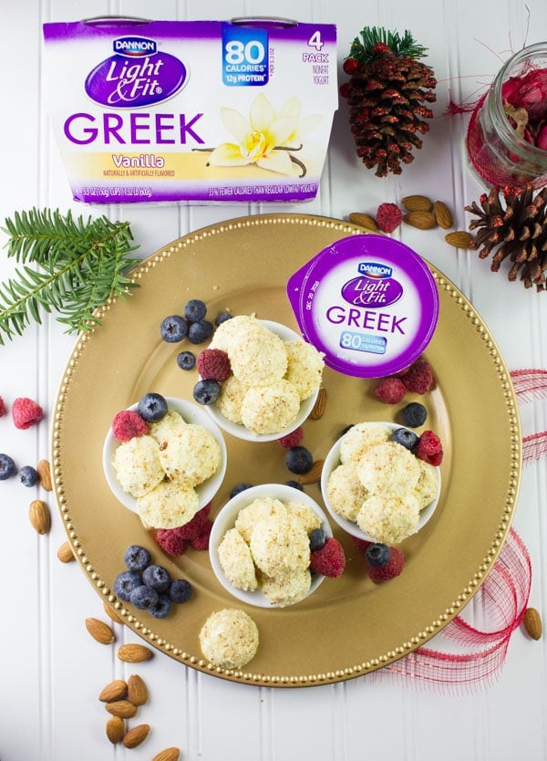 overhead shot of Almond Crunch Greek Yogurt Cheesecake Bites in four cups on a golden plate