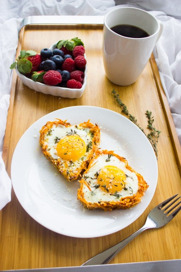Baked Eggs in Sweet Potato Crust with a side of berries and coffee - served on a breakfast tray in bed.