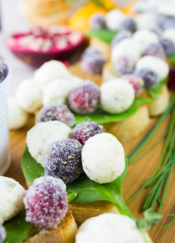 Frosted Cranberries and little cream cheese balls arranged on crostini 