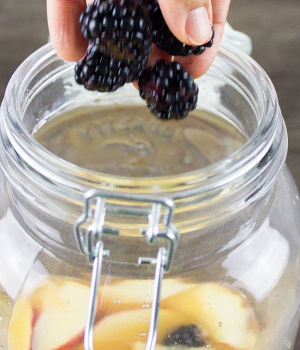 fresh fruit being added to a non alcoholic sangria