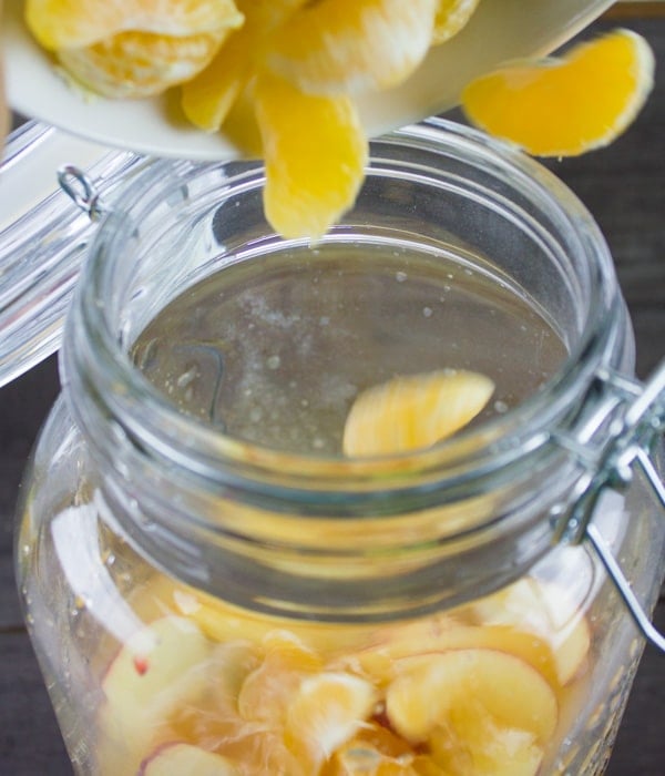 fresh fruit being added to a non alcoholic sangria