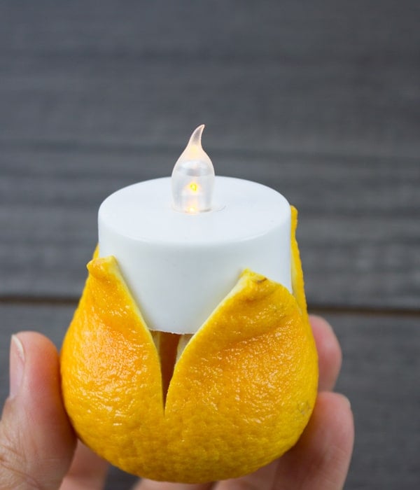 a tangerine being turned into a candle
