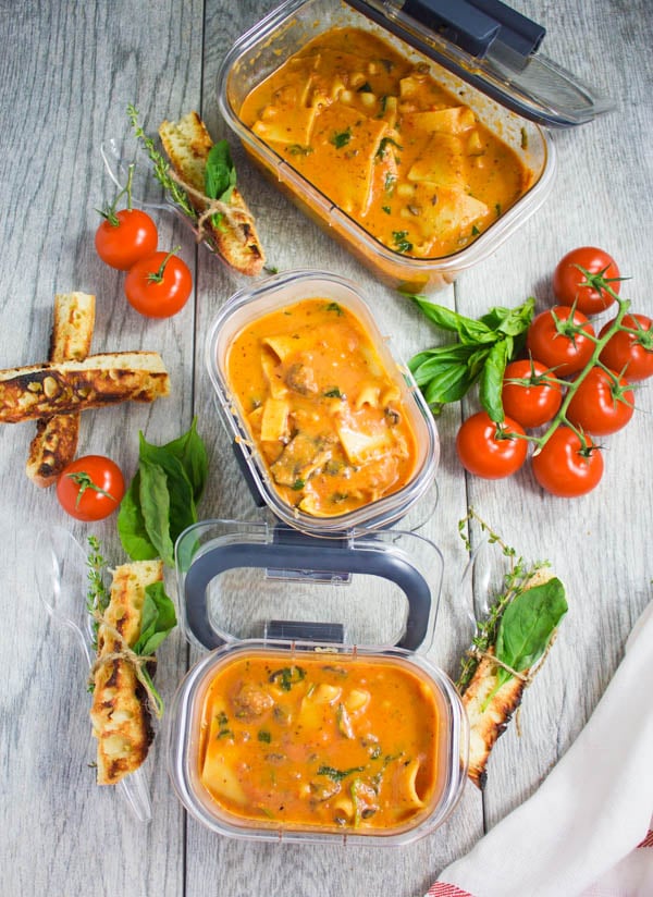 overhead shot of three rubbermaid containers filled with Lasagna Soup with breadsticks on the side