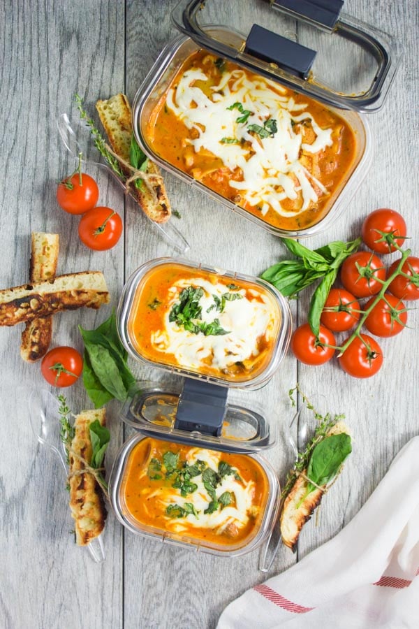 three rubbermaid containers filled with lasagna soup with lots of melted cheese on top