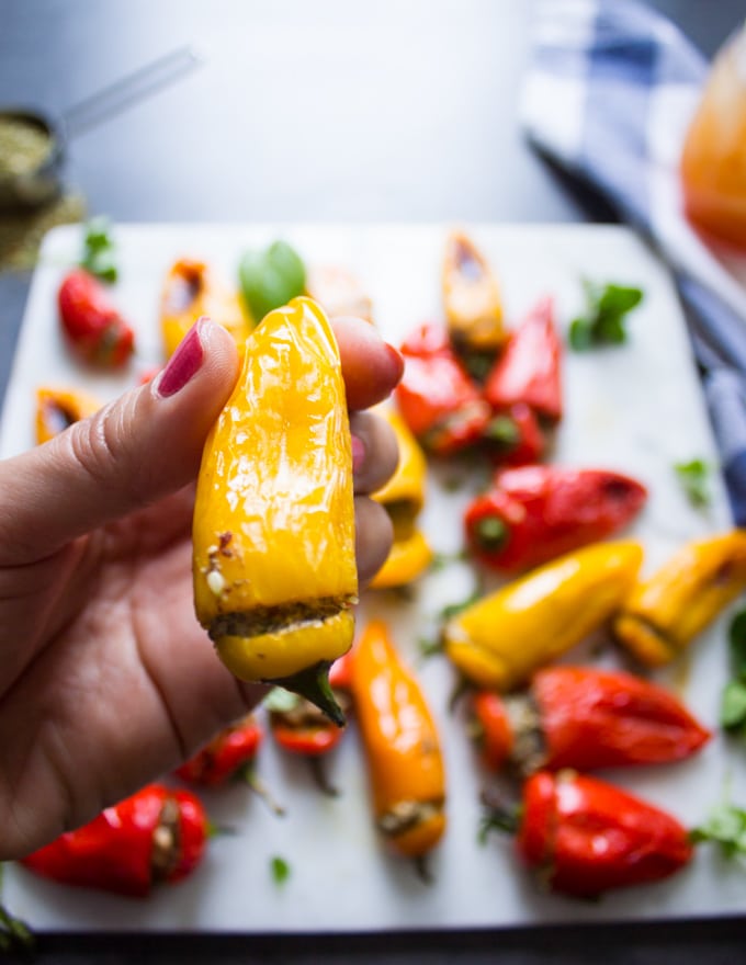 A hand holding a mini yellow stuffed pepper recipe