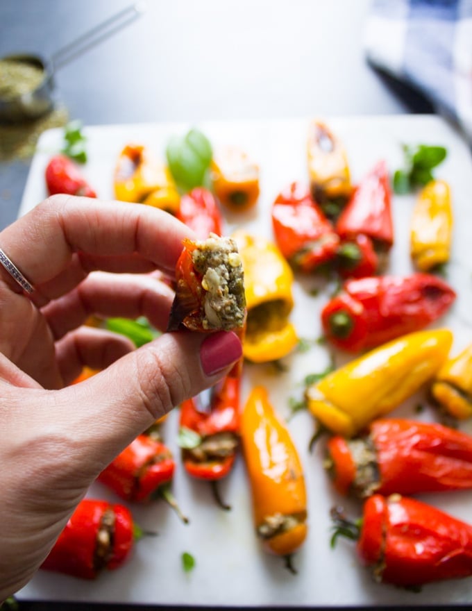 A hand holding a stuffed pepper bitten showing the stuffing