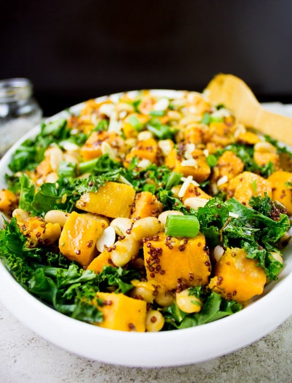 side view of One Pot Quinoa Sweet Potato Salad served in an oval salad bowl sprinkled with slivered almonds and chopped scallions