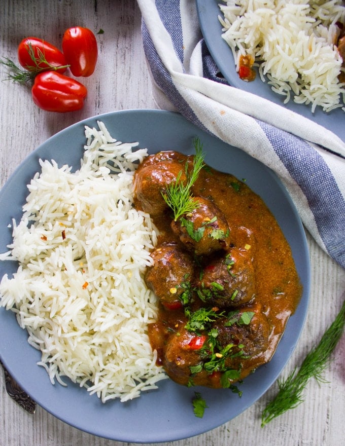 One plate of kofte turkish meatballs over rice in a tomato sauce