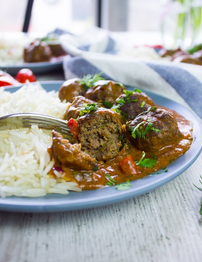 A fork holding a bitten piece of kofte turkish meatballs showing how juicy it is