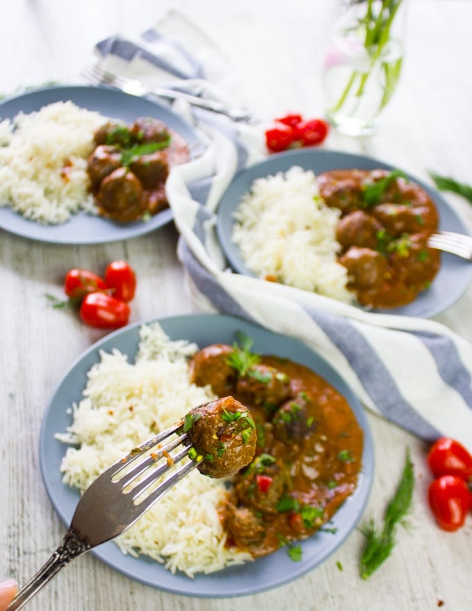 Three plates of Turkish Meatballs and one close up fork holding a meatballs