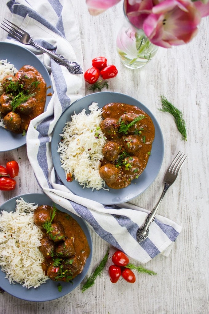 two plates of turkish meatballs in tomato sauce with a tea towel