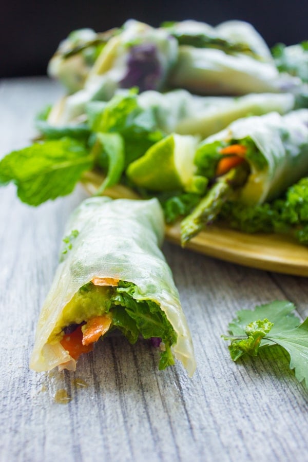 Rice Paper Roll with one bite taken out the front lying on a wooden table