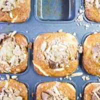 a batch of freshly baked cream cheese banana bread muffins in a muffins tin right our of the oven