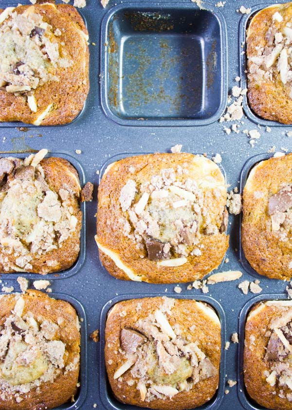 a batch of freshly baked cream cheese banana bread muffins in a muffins tin right our of the oven 