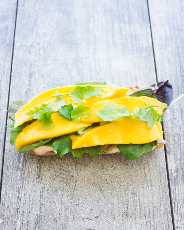 half a ciabatta bun topped with mango slices and cilantro