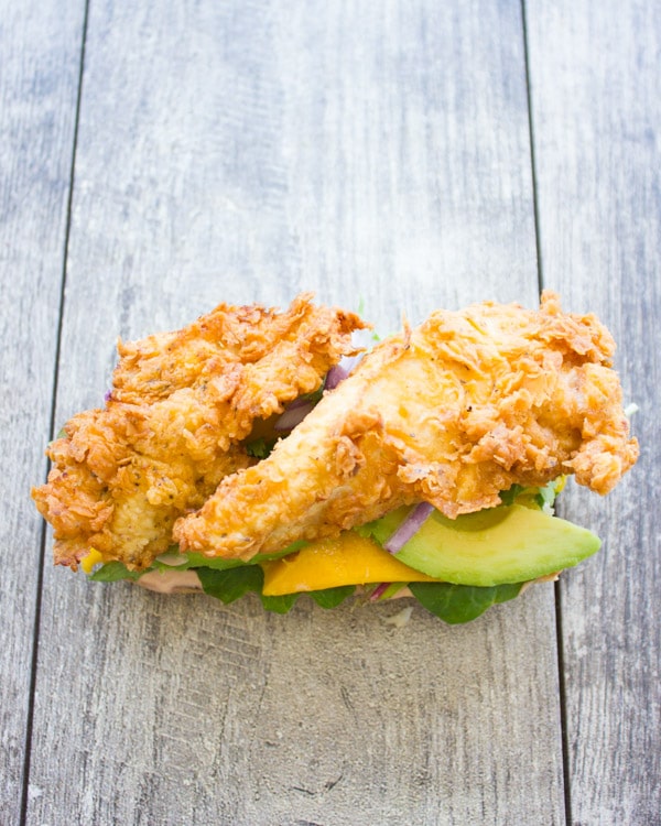 open ciabatta sandwich topped with crispy fried chicken, mango and avocado slices