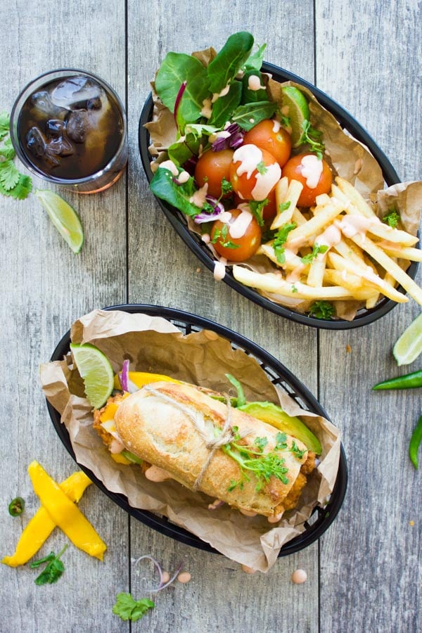 overhead of Sriracha Mango Chicken Sandwich with a side of salad and fries next to it