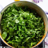 fresh spinach added to the pot of lentils