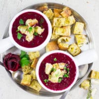 overhead shot of two bowls of Russian Beetroot Soup with croutons