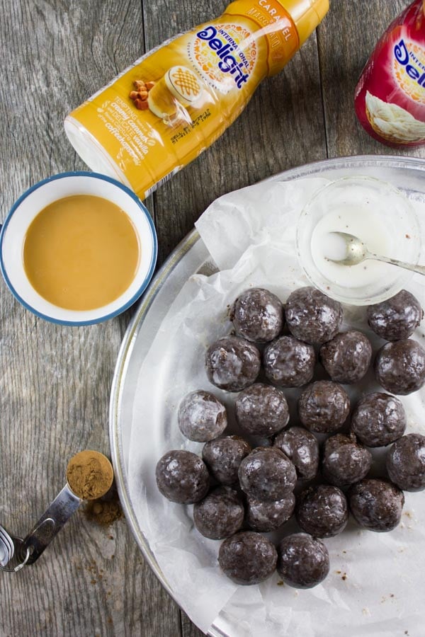 Caramel Spiked Chocolate Donut Holes. The best baked donut holes you'll ever make! tender, fluffy and intensely chocolate-y with a spike of caramel in the donut and glaze! Get the step by step recipe-www.twopurplefigs.com