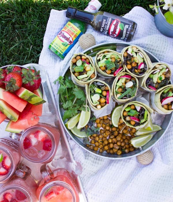 overhead shot of Roasted Chickpeas Wraps on a silver tray served al fresco with summery cocktails and more roasted chickpeas on the side