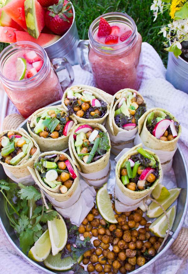 Best Roasted Chickpeas Wraps with kale radishes and spring onions served on a silver tray with some summery cocktails in the background