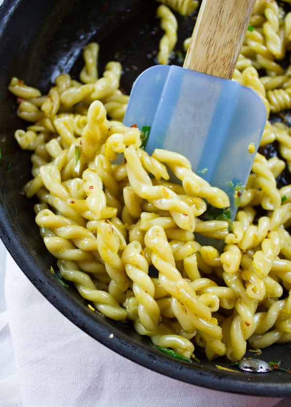 pasta being stirred in a skillet 