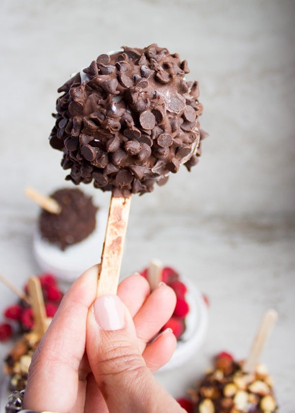 A hand holding an ice cream pop close up with the mini chocolate chips
