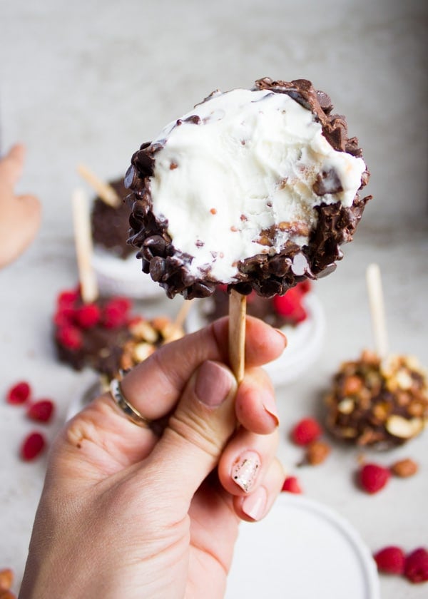 A hand holding an eaten up ice cream pop with the ice cream inside showing