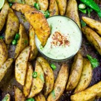 Perfect Baked Potato Wedges with Avocado Crema. Upgrade your average potatoes with these crispy spicy perfect baked potato wedges! Cool them off with a dip in the most luscious avocado sauce! Step by Step recipe at www.twopurplefigs.com