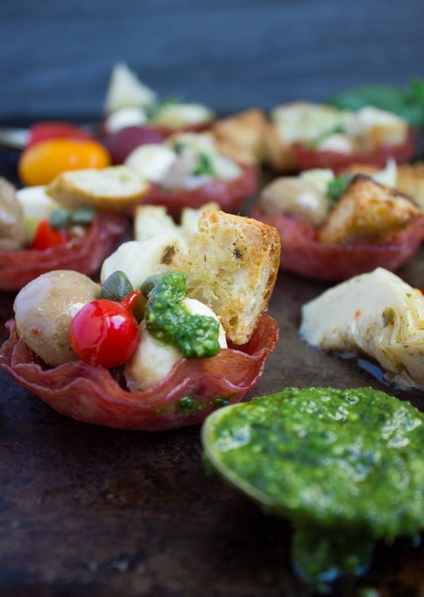 side-view of Antipasto piled up in Bite Size Salami Cups with some homemade pesto on the side