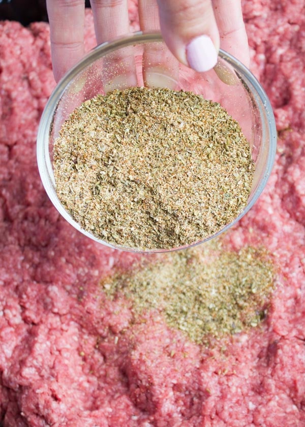 minced lamb being seasoned with a spice blend before being shaped into patties.