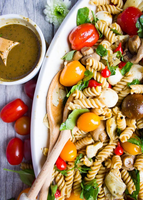 overhead shot of Warm Antipasto Platter Pasta with a small side dish of basil sauce on the side