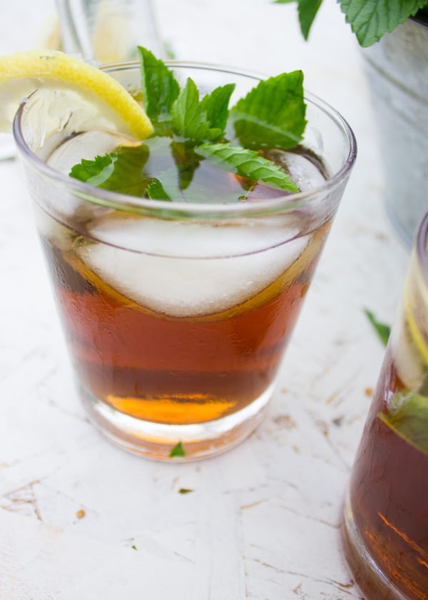 close-up of a glass of ice tea with ice cubes and mint leaves as decoration.