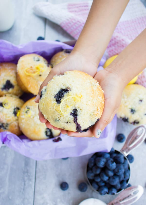 Close-up of a Blueberry Muffin With Lemon Sugar Crunch Topping held by a child 