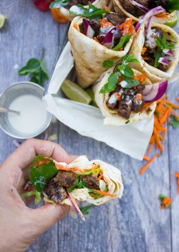 Spicy Harissa lamb shoulder chunks in pita cones with Tahini sauce. A serious Crowd Pleaser that's Loaded with Flavors and a Secret Tip for charring Lamb Chunks I learned form my grandma! Get the recipe and Step by Step at www.twopurplefigs.com