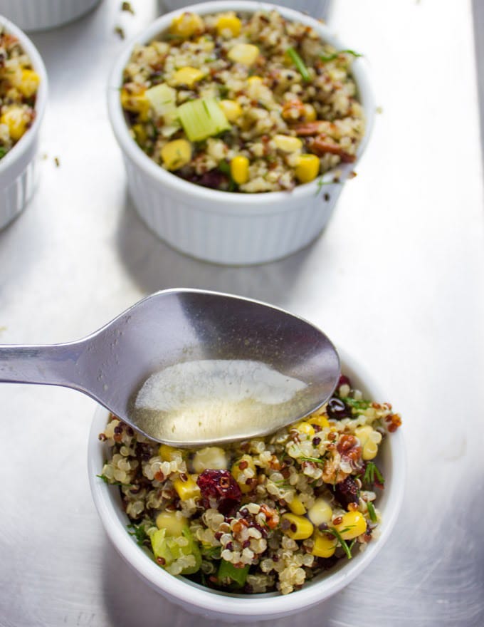 broth being drizzled on top of an individual ramekin with quinoa stuffing