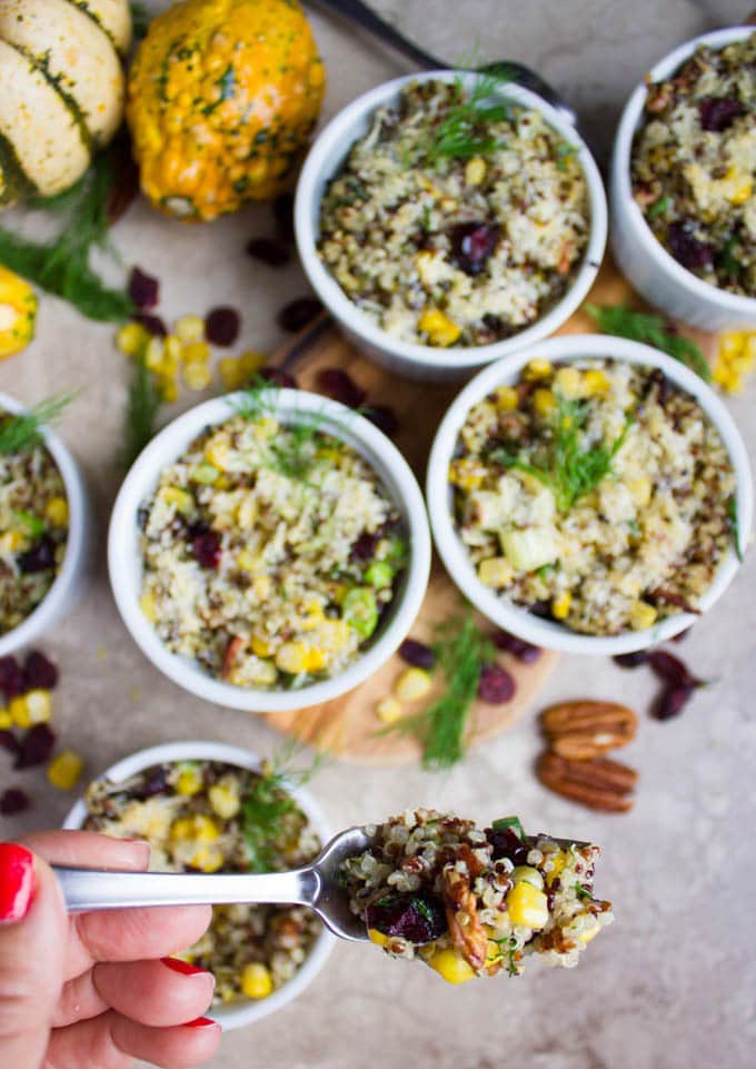a fork loaded with quinoa stuffing balanced over individual ramekins with stuffing