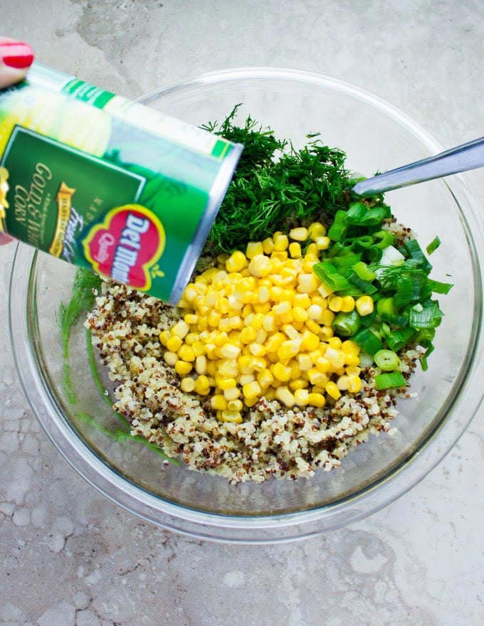 ingredients for quinoa stuffing being tossed in a salad bowl