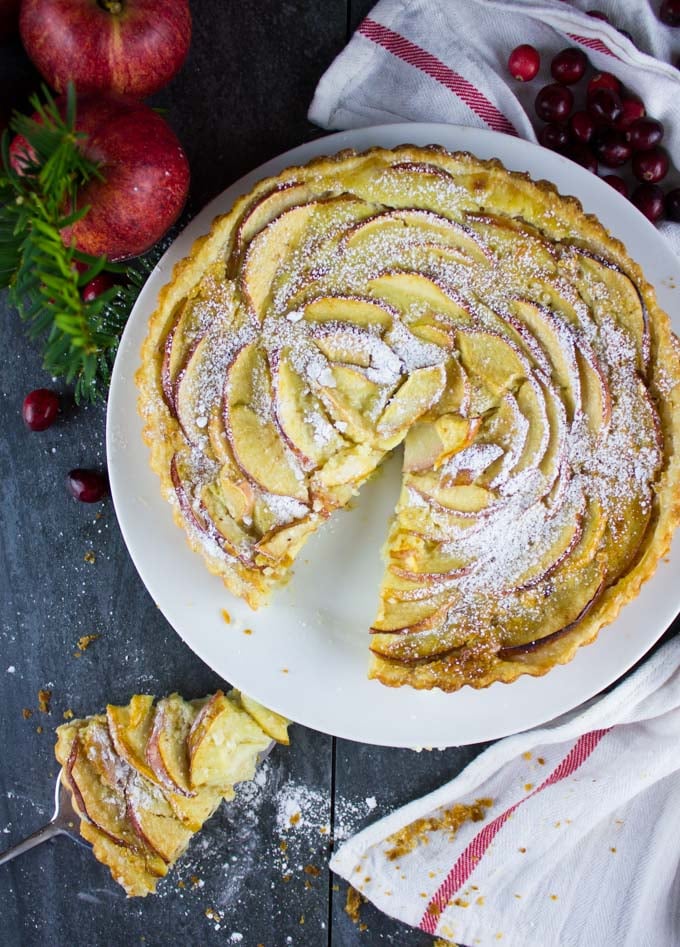 overhead of sugar-dusted Swiss Apple Tart with one slice cut out