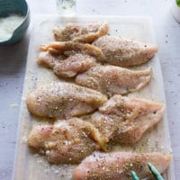 chicken breasts seasoned on both sides on a cutting board