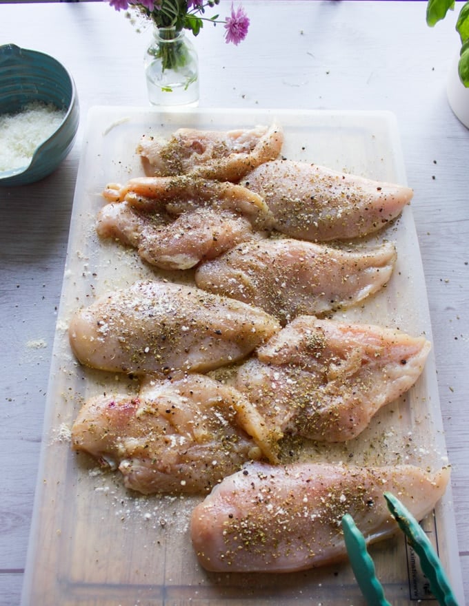 chicken breasts seasoned on both sides on a cutting board