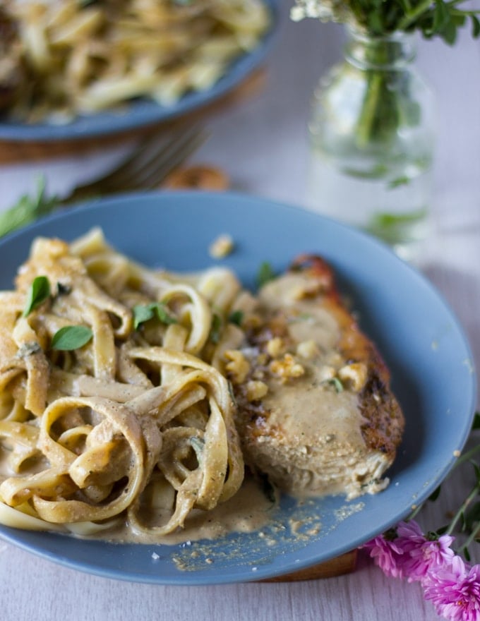 A sliced off chicken breast showing the creamy walnut sauce dredged over the chicken