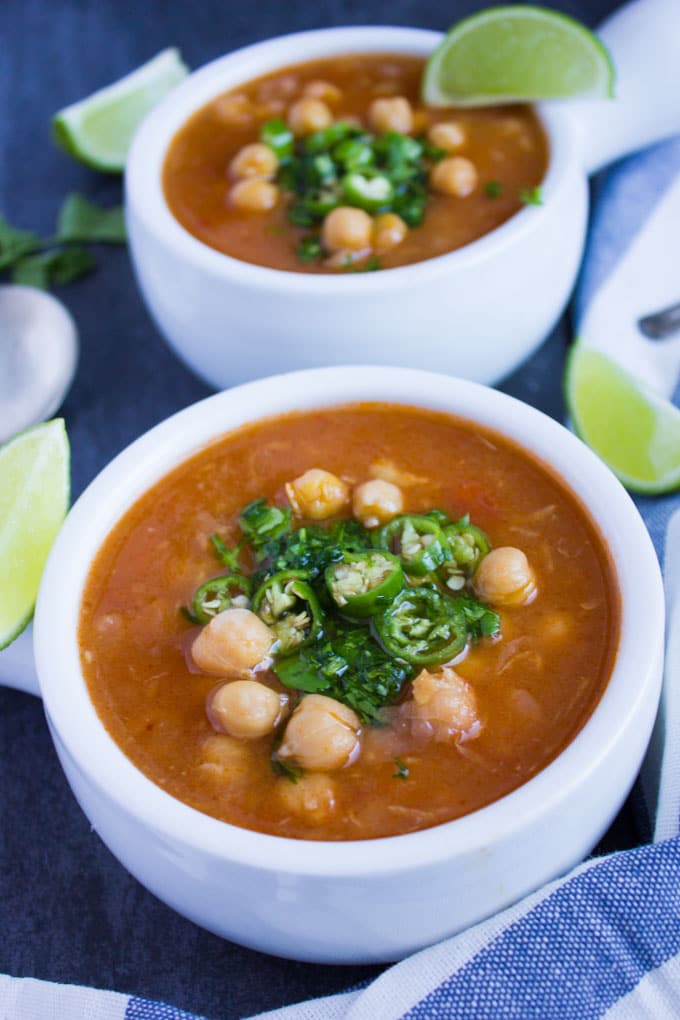 close-up of a small bowl of Garlic Chickpea Soup topped with sliced green chilies