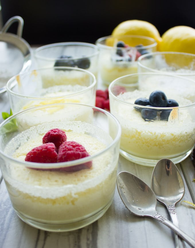 side view of Easy Mini Lemon Pudding Cakes topped with berries